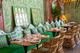 Mille Feuilles wallpaper in Grass with La Jungle green upholstery on scallop-back seating at Sushita Green café, Madrid. Interior by LHA Designs, photography by Alice Morgan – a richly layered botanical space.
